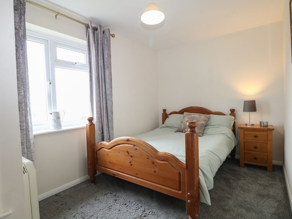 A bedroom with a wooden bed and bedside table at Walmer Court Farmhouse in Deal