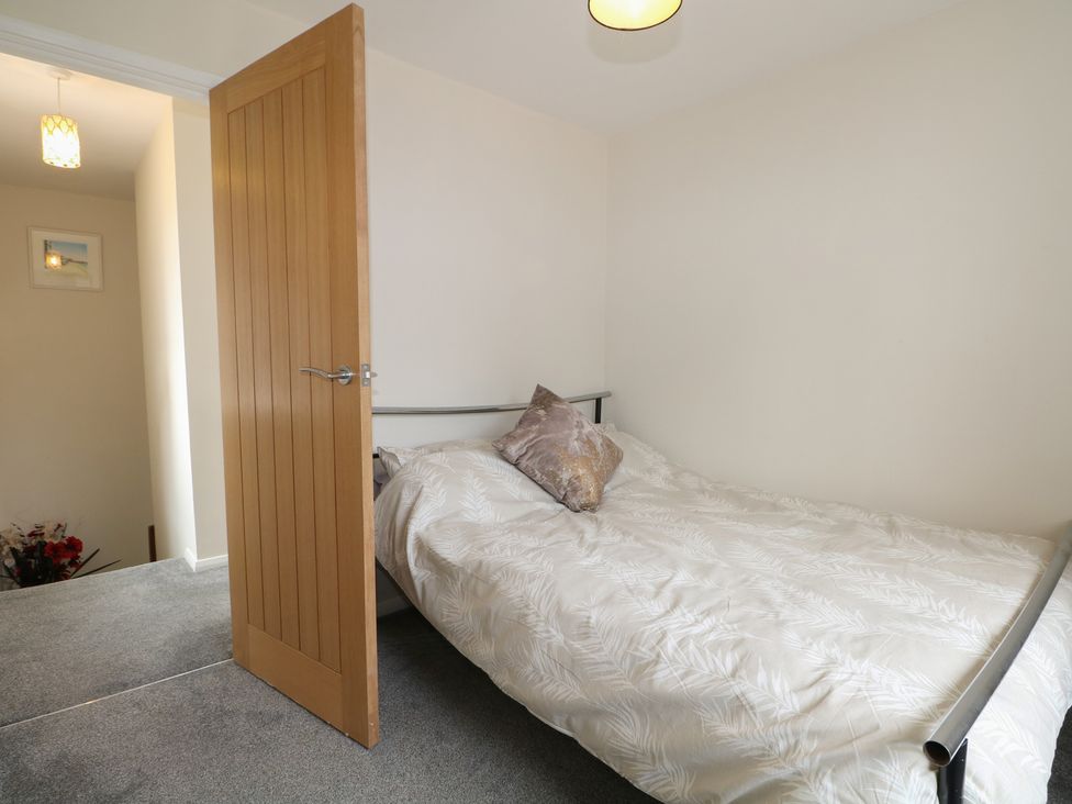 A bedroom with a bed and light fixture at Walmer Court Farmhouse, Deal
