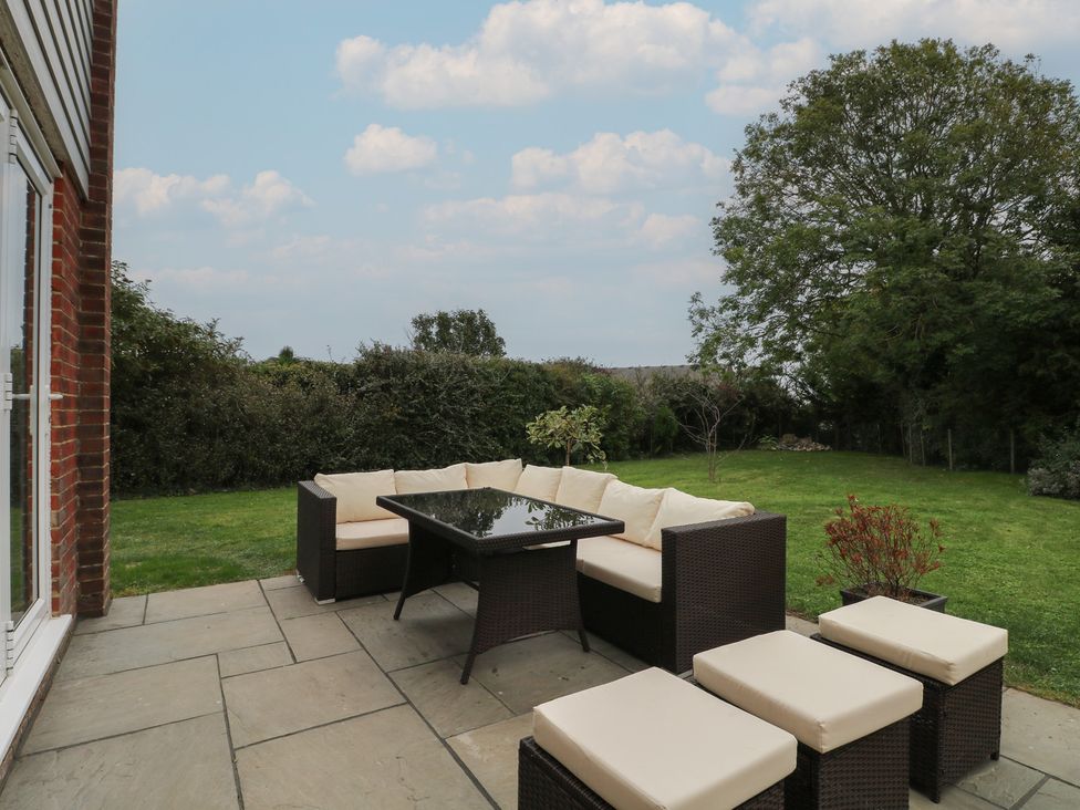 An outdoor patio with seating and a table at Walmer Court Farmhouse in Deal