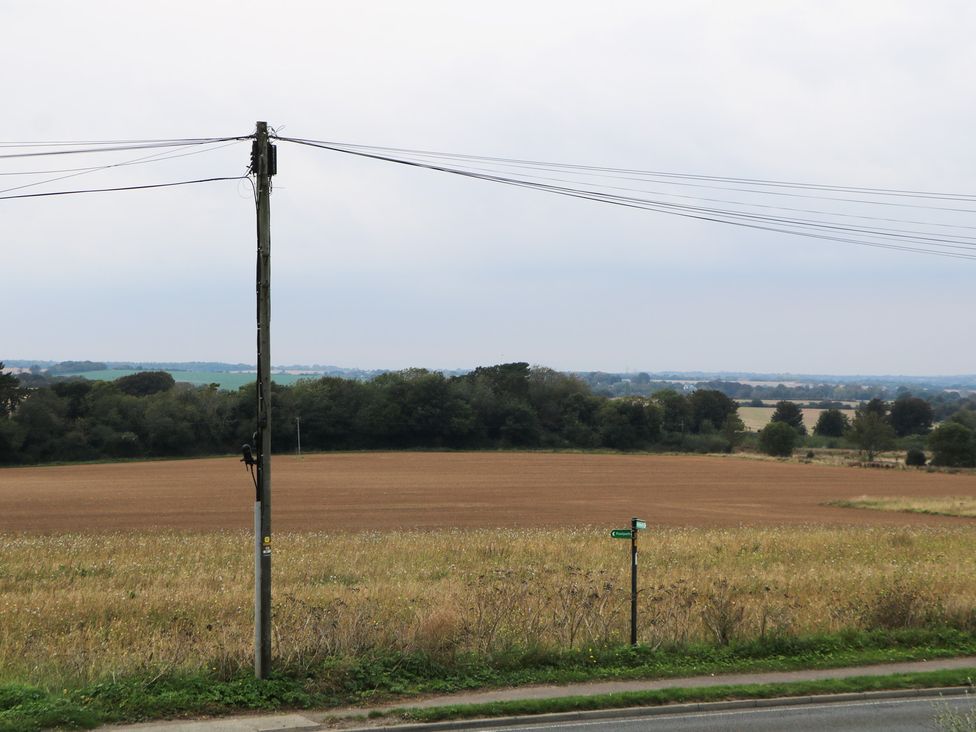 A field with a telephone pole and road sign at Walmer Court Farmhouse in Deal