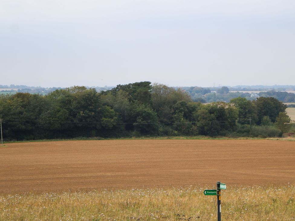 A field with trees and a signpost at Walmer Court Farmhouse in Deal
