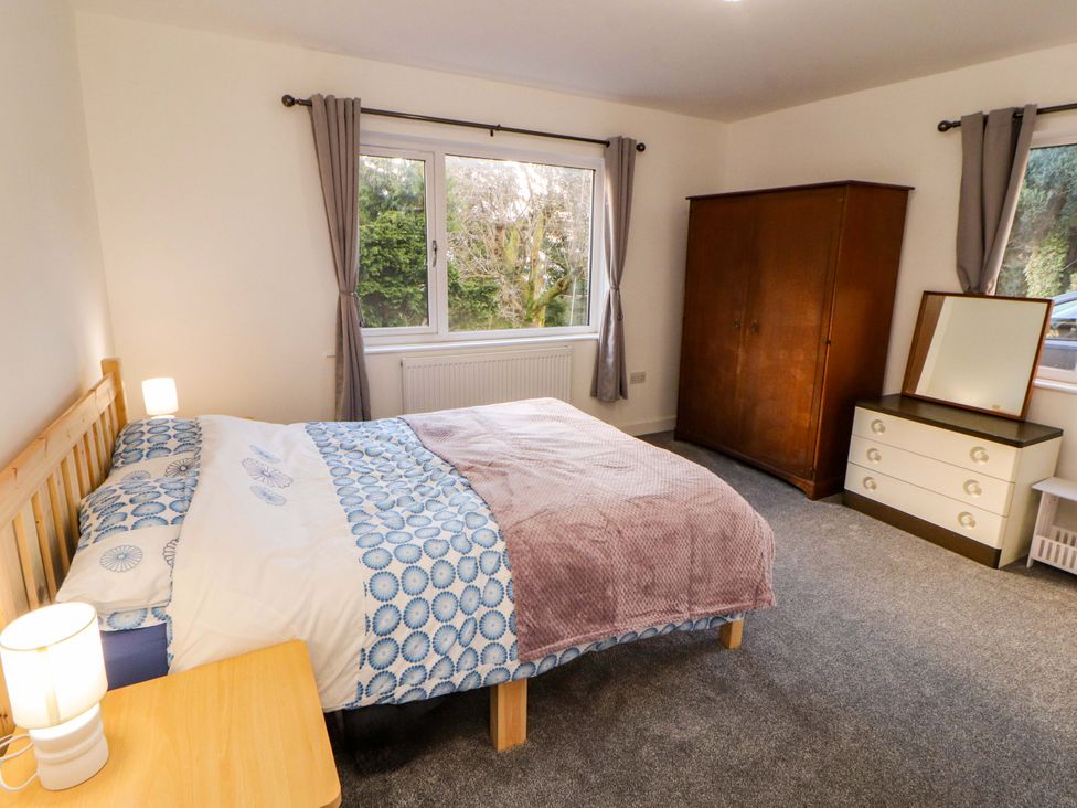 A bedroom with a bed, wardrobe, and dresser at Westerlodge Threlkeld near Keswick