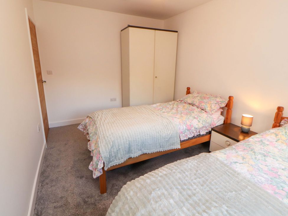 A bedroom with two beds and a wardrobe at Westerlodge in Threlkeld near Keswick