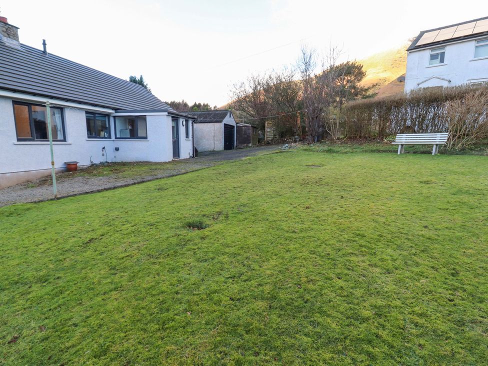 A garden with grass and a bench at Westerlodge Threlkeld near Keswick