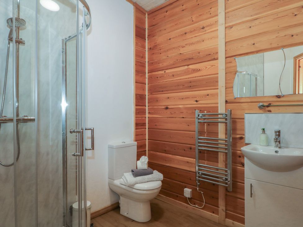 A bathroom with a shower, toilet, and sink at Woodlands View in Leek