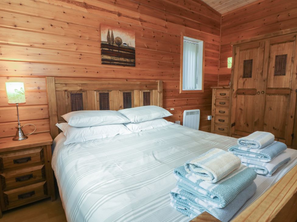 A bedroom with a bed and nightstand at Woodlands View in Leek