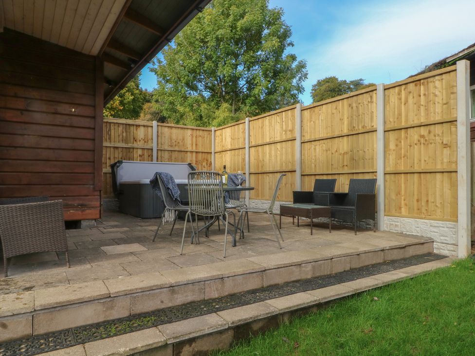 An outdoor seating area with table and chairs at Woodlands View in Leek