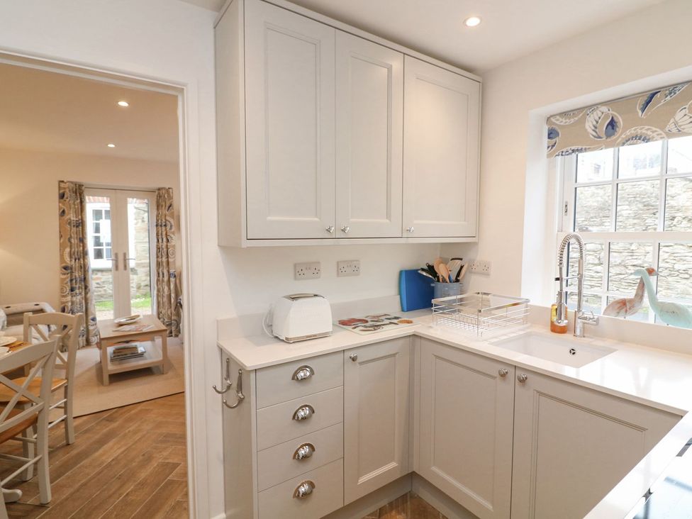 A kitchen with cabinets and a sink at Quay cottage Salcombe