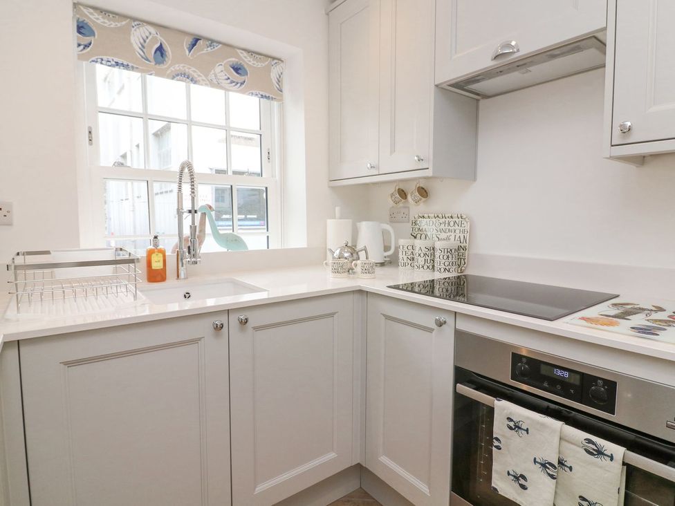 A kitchen with a sink and stove at Quay cottage in Salcombe