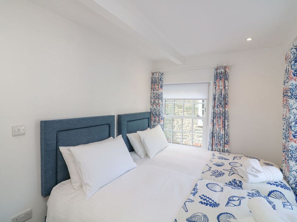 A bedroom with two beds and window at Quay cottage in Salcombe
