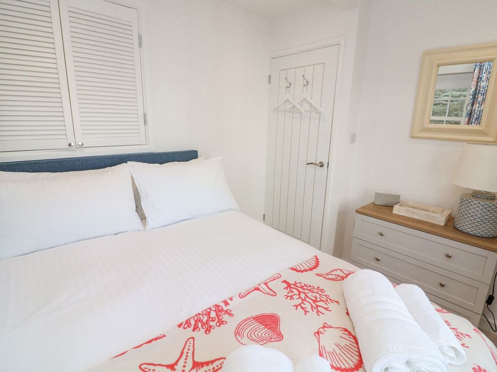 A bedroom with a bed and a bedside table at Quay cottage Salcombe