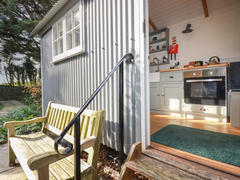 A kitchen with a door and window leading to the outside at Hillbre Shepherd Hut, Padstow
