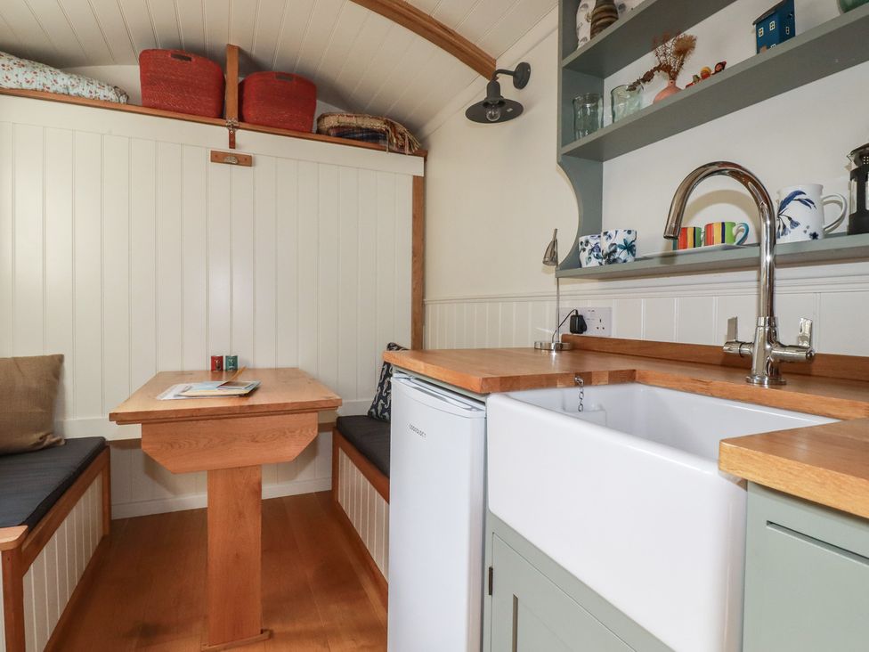 A kitchen with a table and sink at Hillbre Shepherd Hut in Padstow
