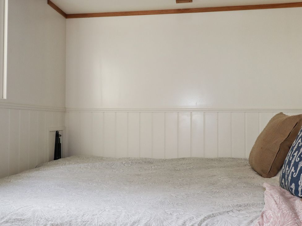A bedroom with a bed and pillows at Hillbre Shepherd Hut in Padstow