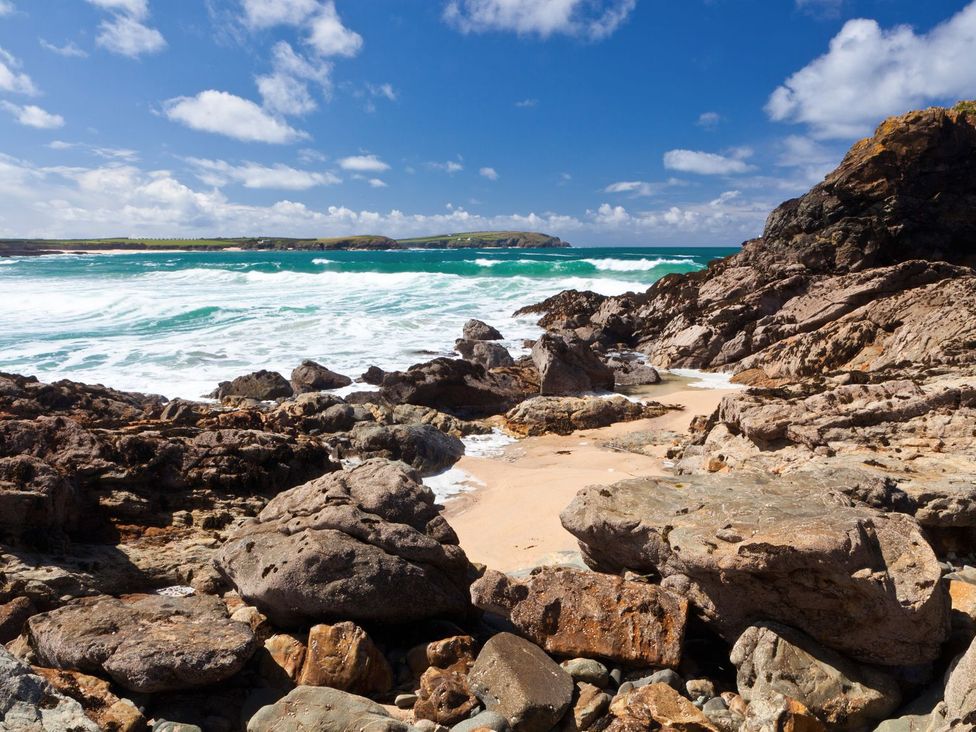A beach area with rocks and waves at Hillbre Shepherd Hut Padstow