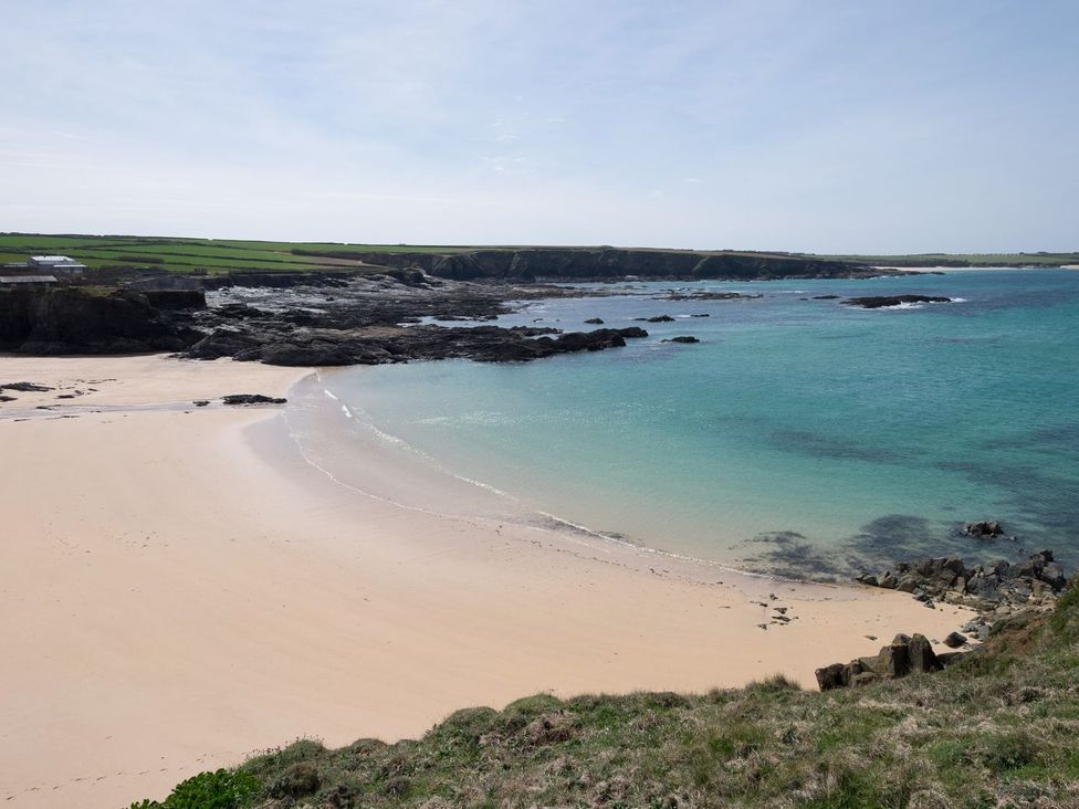 A beach with water and rocks at Hillbre Shepherd Hut in Padstow