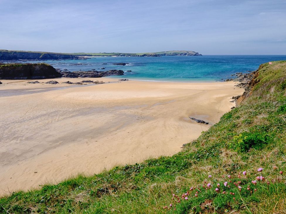A beach with sand and rocks at Hillbre Shepherd Hut in Padstow