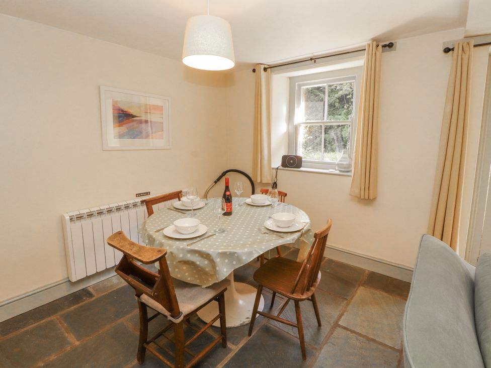 A dining room with a table and chairs at Rock Cottage in Milnthorpe