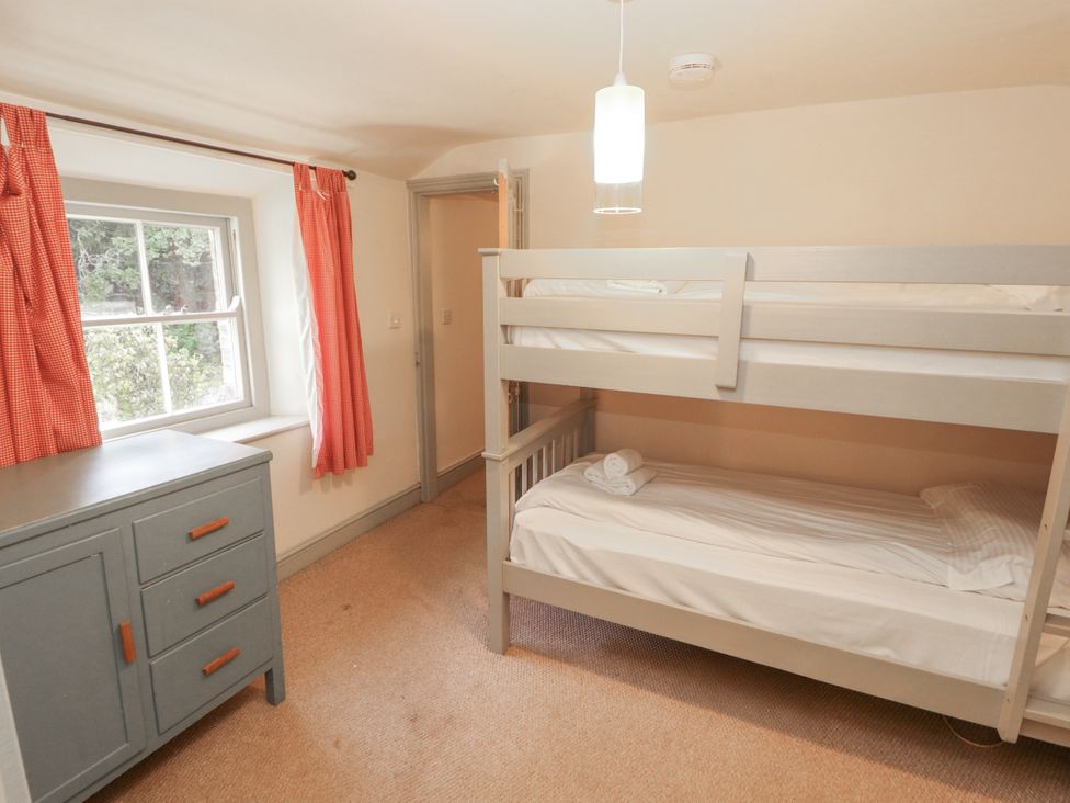 A bedroom with a bunk bed and dresser at Rock Cottage in Milnthorpe