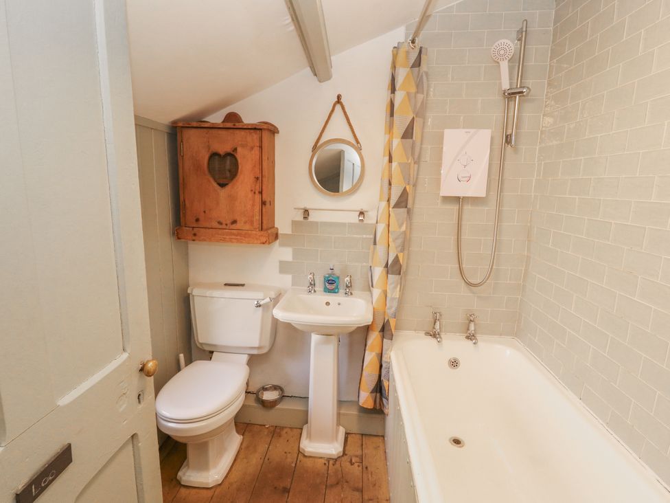 A bathroom with a bathtub, sink, and toilet at Rock Cottage in Milnthorpe