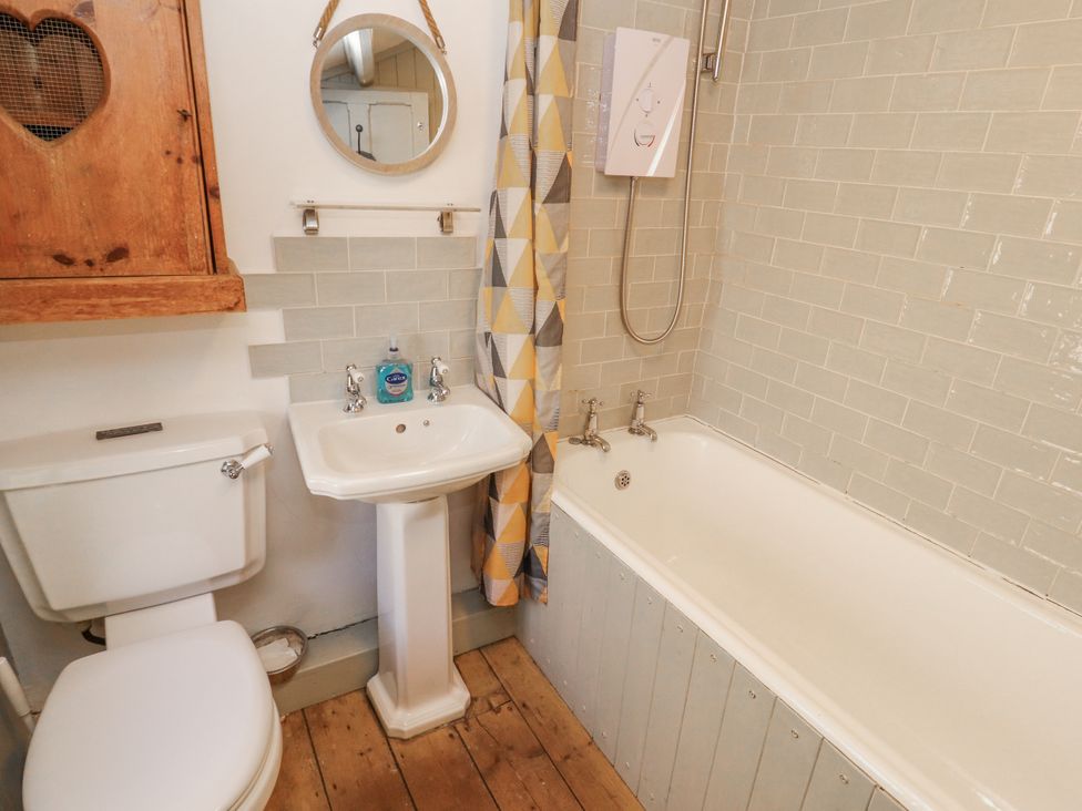 A bathroom with a sink, toilet and bathtub at Rock Cottage in Milnthorpe