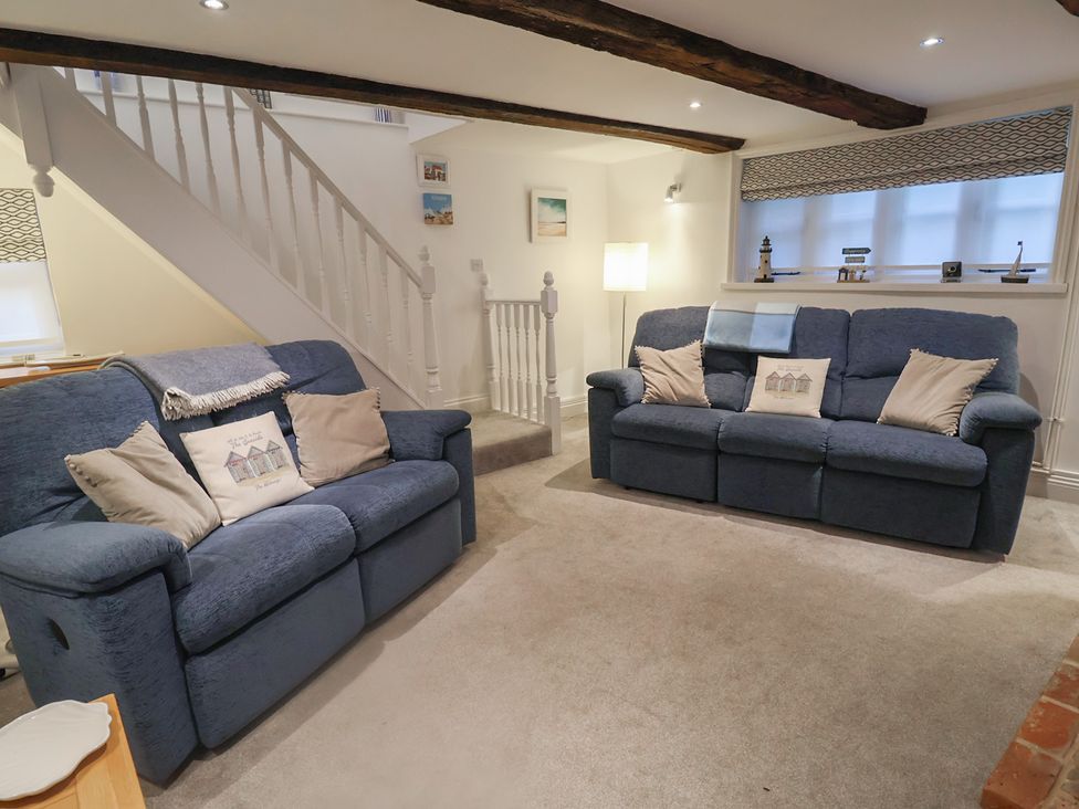 A living room with sofas and a lamp at Nutshell in Aldeburgh
