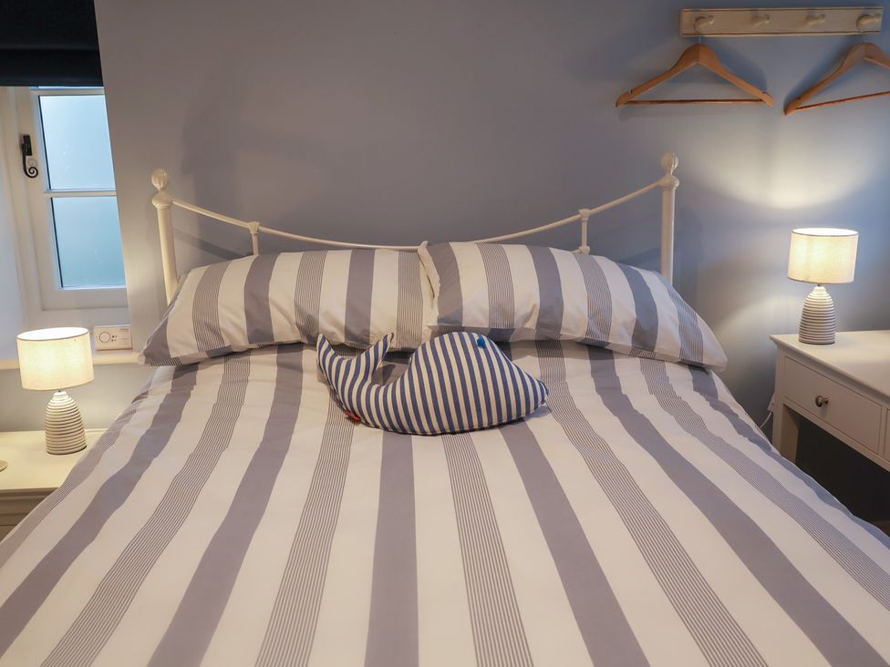 A bedroom with a bed and pillows at Nutshell in Aldeburgh