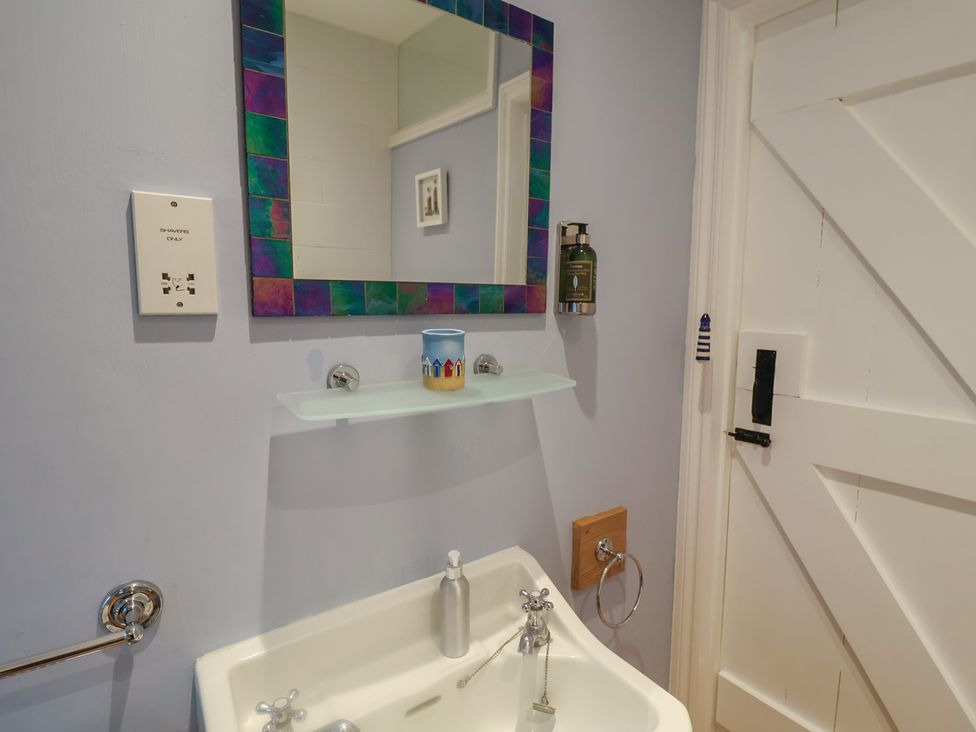 A bathroom with a sink and mirror at Nutshell in Aldeburgh