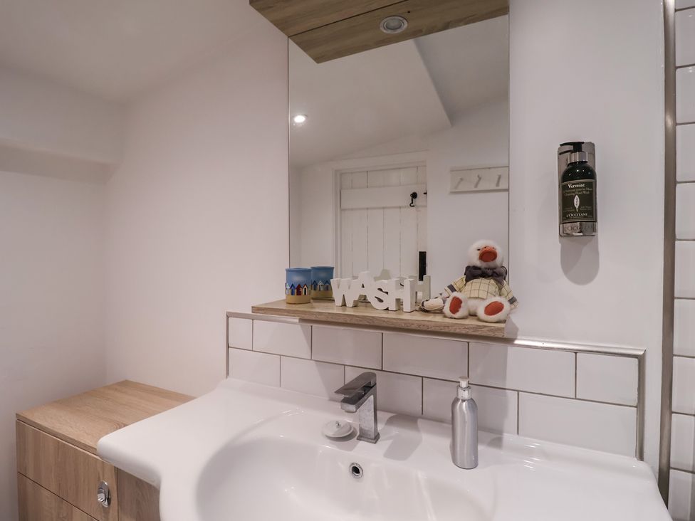 A bathroom with a sink and mirror at Nutshell in Aldeburgh
