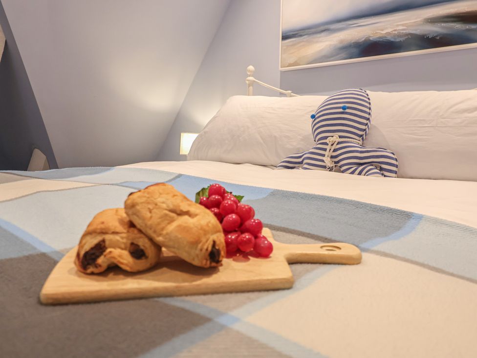A bedroom with a bed and food on a tray at The Nutshell in Aldeburgh