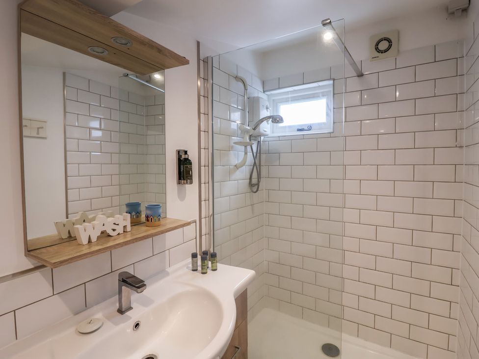 A bathroom with a shower and sink at The Nutshell in Aldeburgh