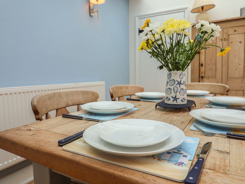 A dining room with a table set for meals at The Nutshell in Aldeburgh