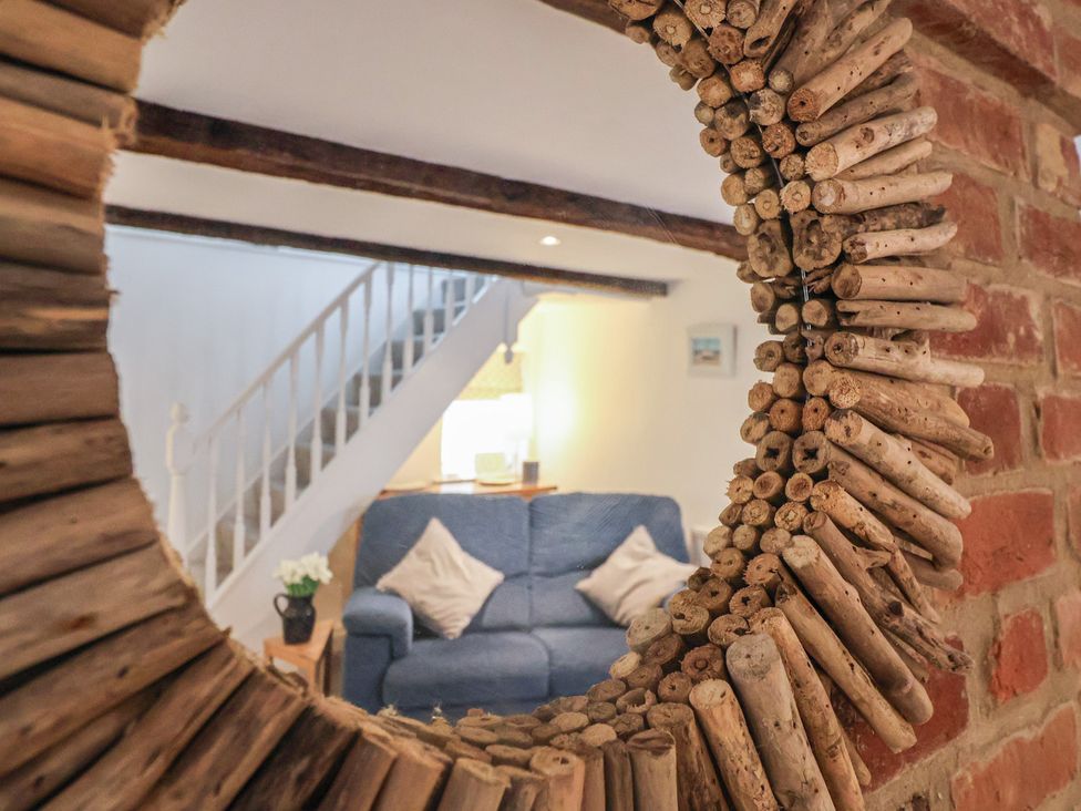 A living room with a mirror and couch at The Nutshell in Aldeburgh