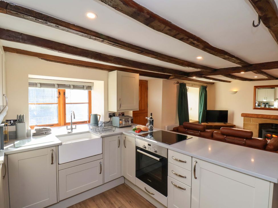 A kitchen with sink and oven at Dove Cottage in Sneaton near Ruswarp