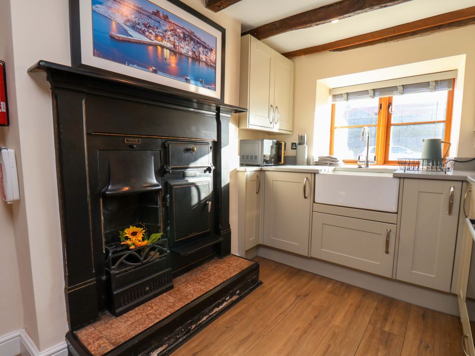 A kitchen with cabinets and stove at Dove Cottage Sneaton near Ruswarp