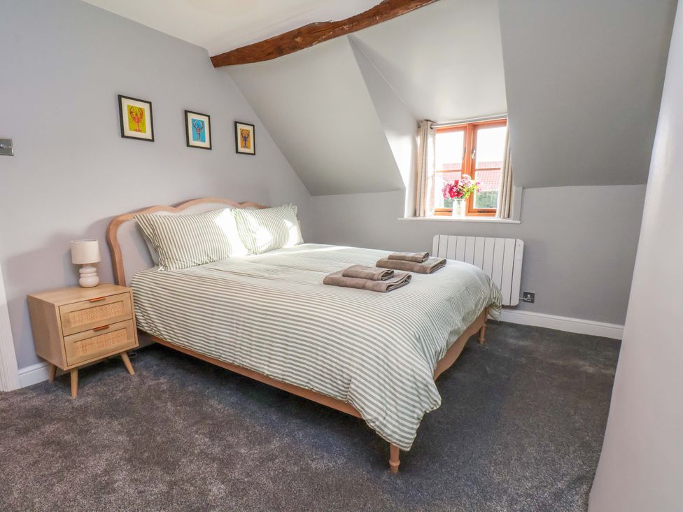 A bedroom with a bed and nightstand at Dove Cottage in Sneaton near Ruswarp
