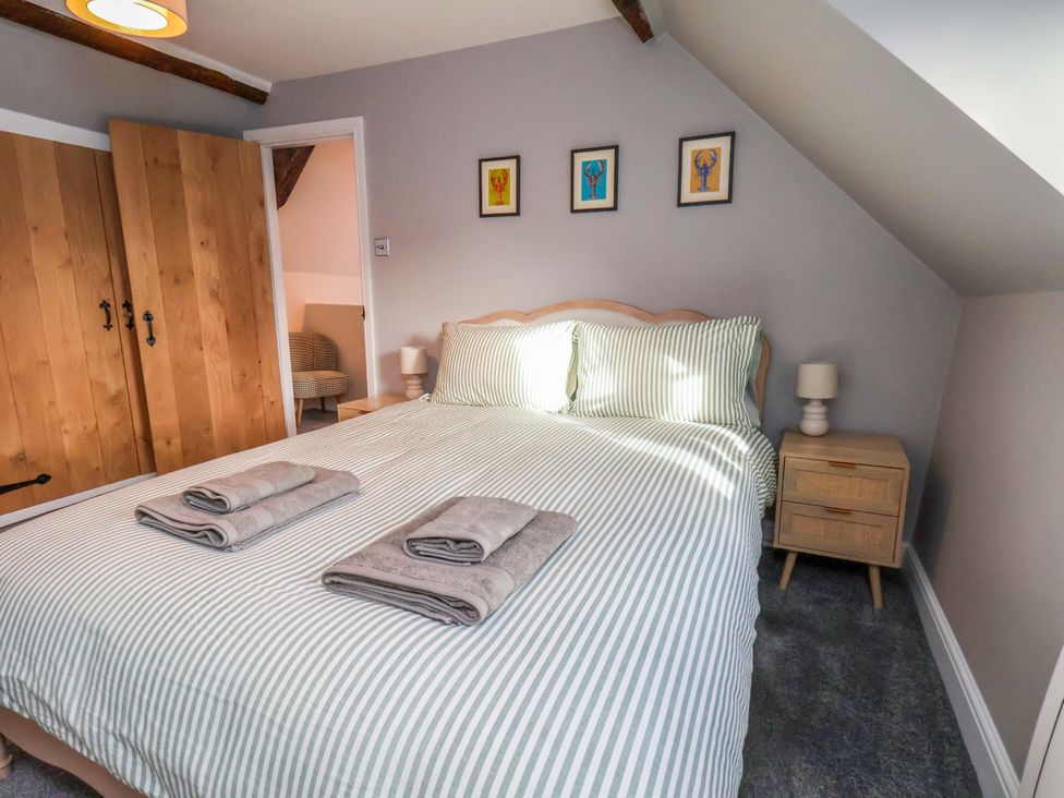 A bedroom with a double bed and wardrobe at Dove Cottage Sneaton near Ruswarp
