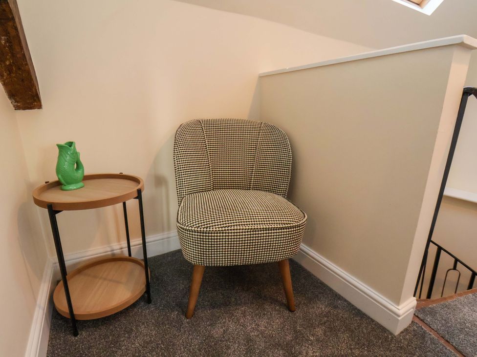 A chair and side table with a pitcher at Dove Cottage Sneaton near Ruswarp