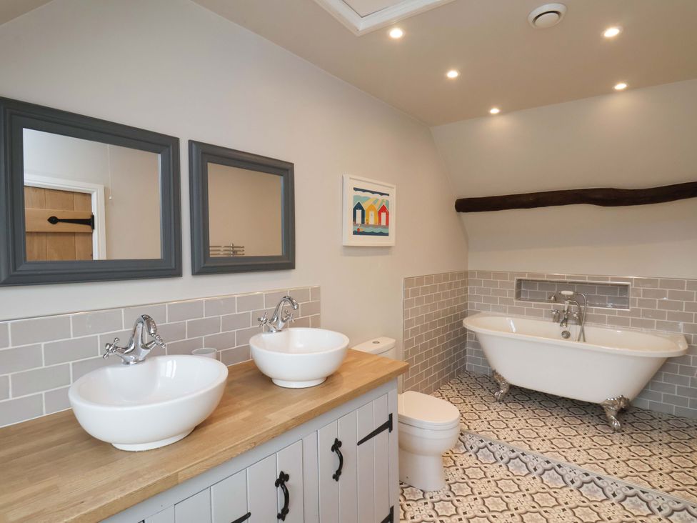 A bathroom with two sinks and a bathtub at Dove Cottage Sneaton near Ruswarp