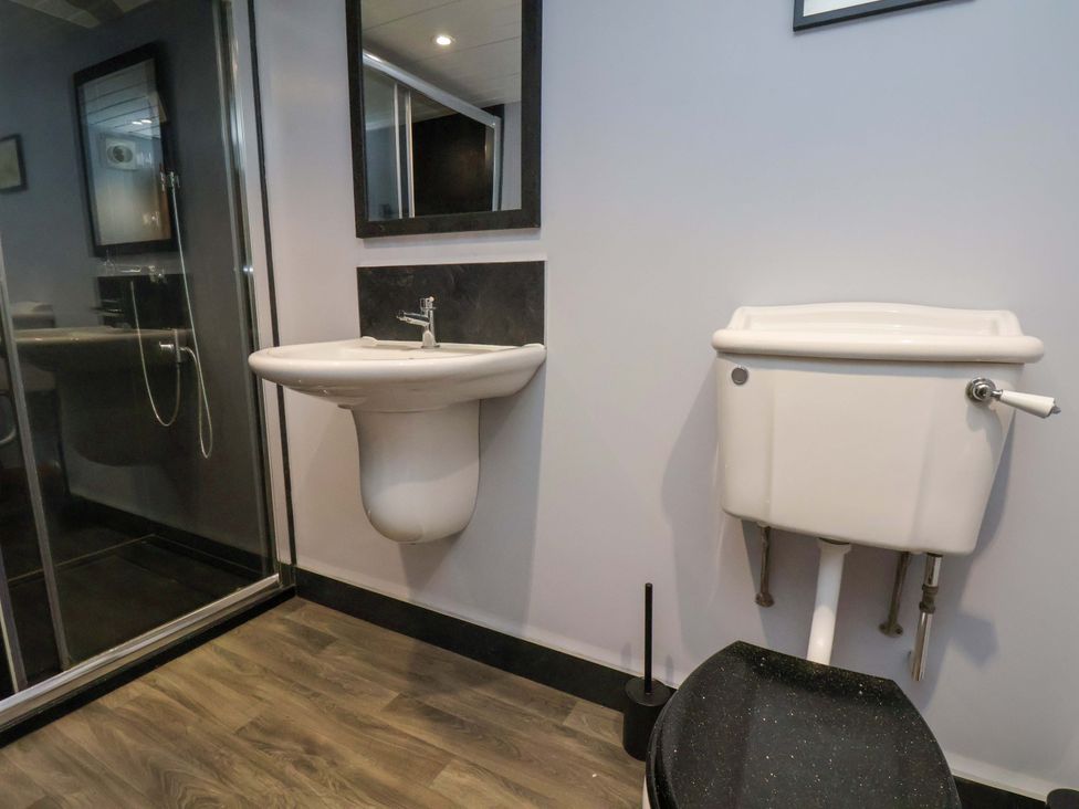 A bathroom with a sink, toilet, and shower at Dove Cottage in Sneaton near Ruswarp
