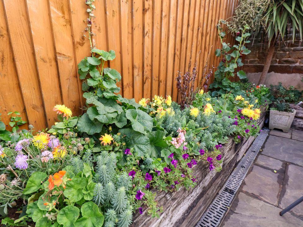 A garden with flowers in a planter at Dove Cottage in Sneaton near Ruswarp
