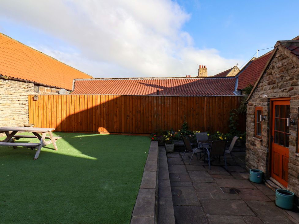 A garden with a picnic table and chairs at Dove Cottage in Sneaton near Ruswarp