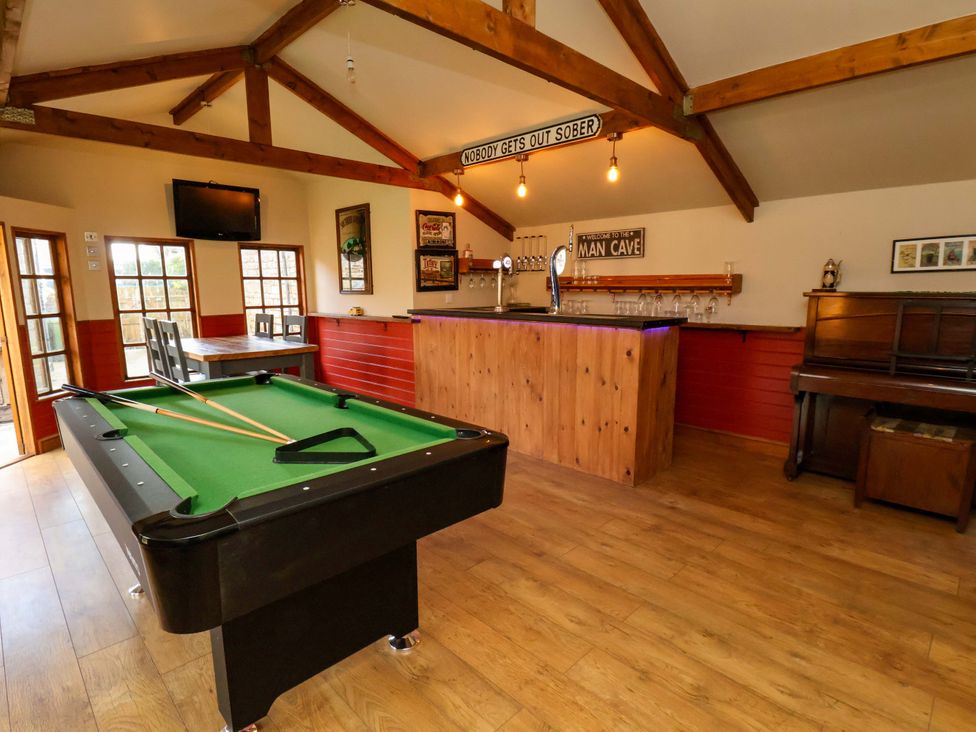A man cave with a pool table and bar at Dove Cottage in Sneaton near Ruswarp
