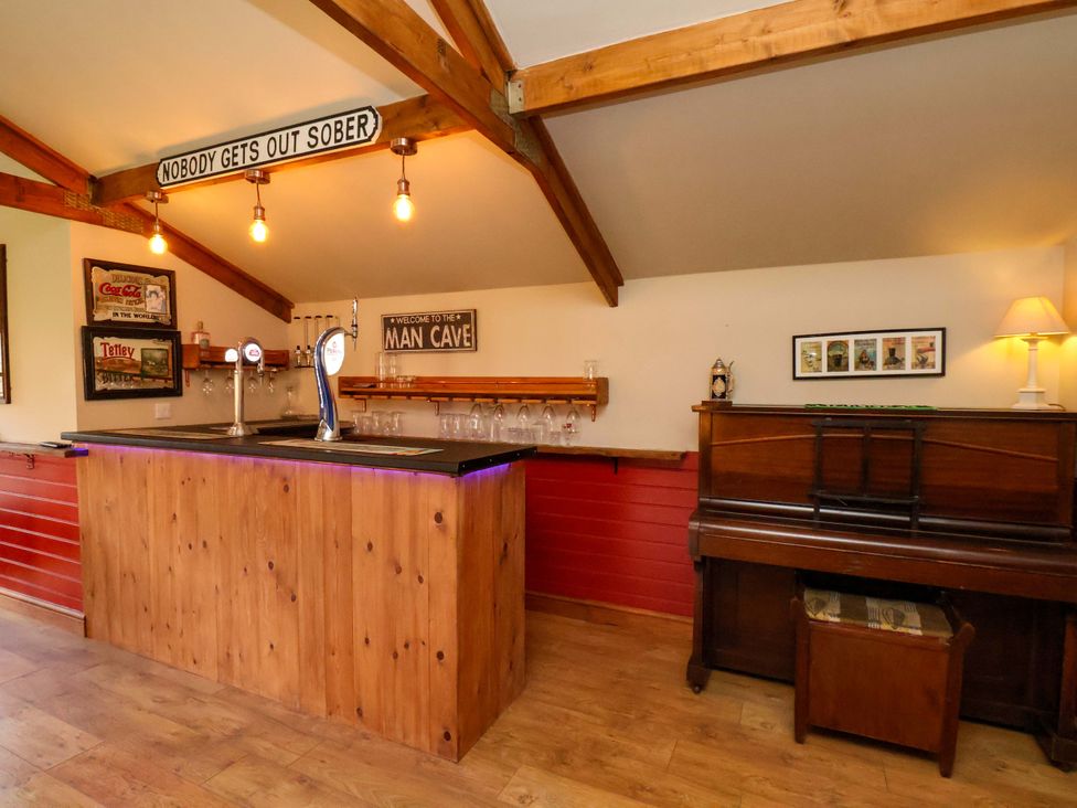 A man cave with a bar and piano at Dove Cottage in Sneaton near Ruswarp