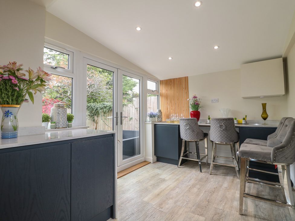 A kitchen with bar stools and a counter at No.12 Alexandra Avenue Sutton-in-Ashfield