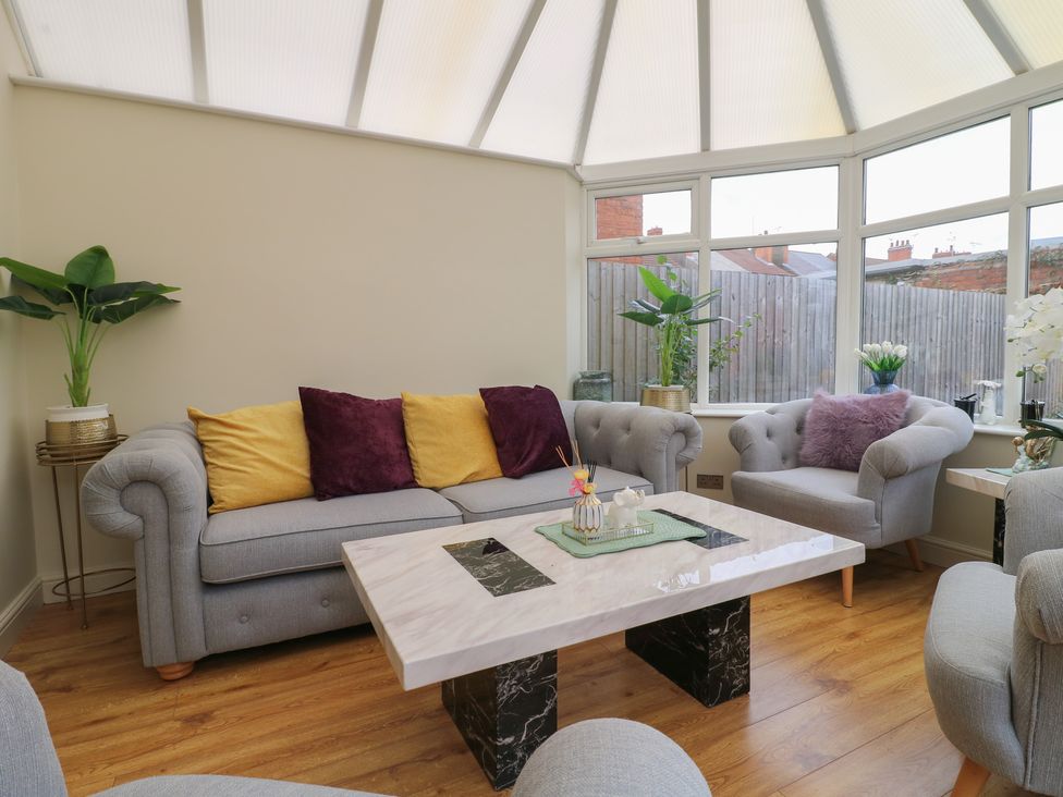 A conservatory with a sofa and coffee table at No.12 Alexandra Avenue Sutton-in-Ashfield
