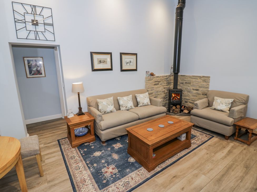A living room with a sofa and armchair at Lily Stables in Black Bourton near Bampton, Oxfordshire