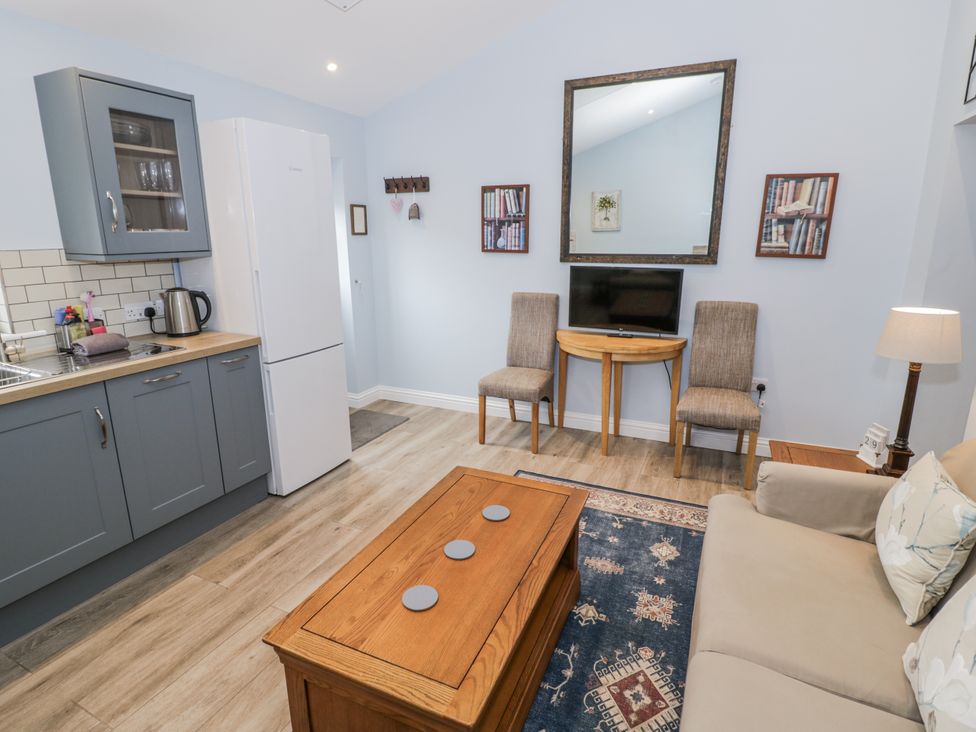 A living room with a kitchen area and seating at Lily Stables Black Bourton near Bampton Oxfordshire