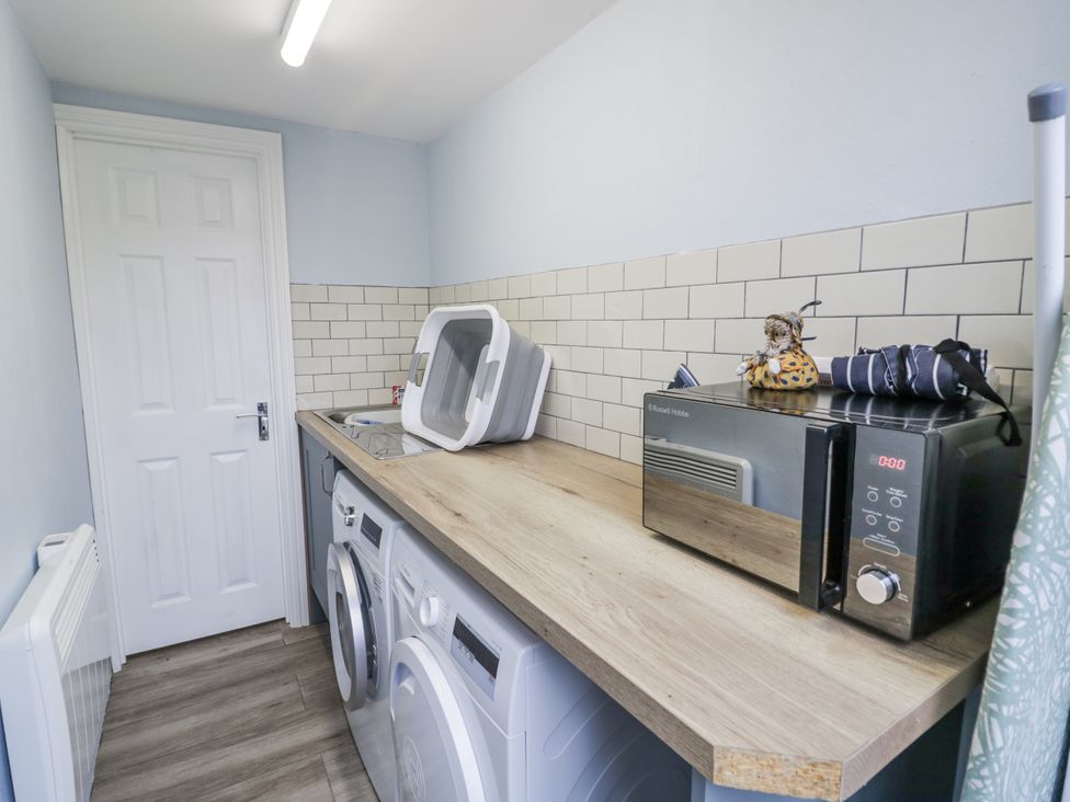 A laundry room with washing machine, dryer and microwave at Lily Stables in Black Bourton near Bampton, Oxfordshire
