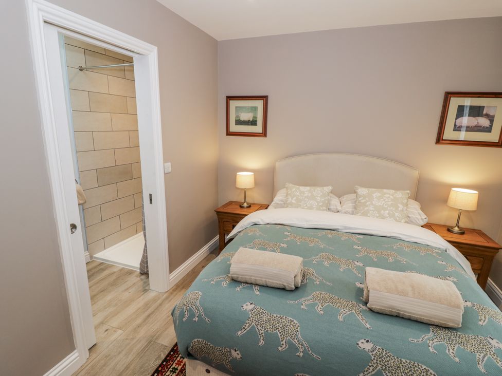 A bedroom with a double bed and shower stall at Lily Stables Black Bourton near Bampton Oxfordshire